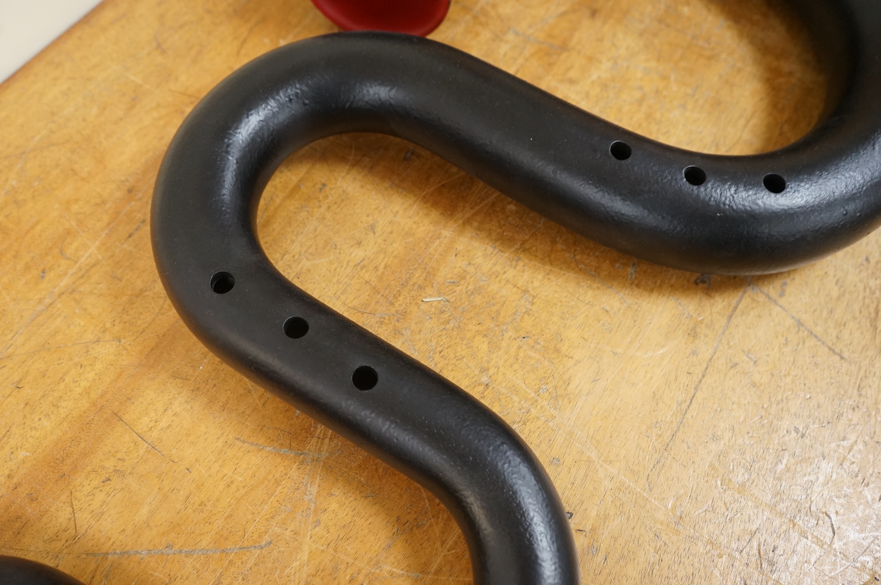 A black painted serpent open hole wind musical instrument, with brass neck (missing mouthpiece).